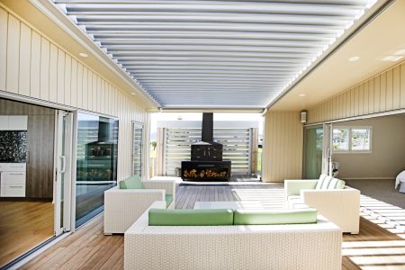Engel Fire in a modern semi-indoor outdoor living space with a view of the backyard.